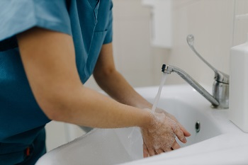 Female medical worker meticulously washing her hands with water.